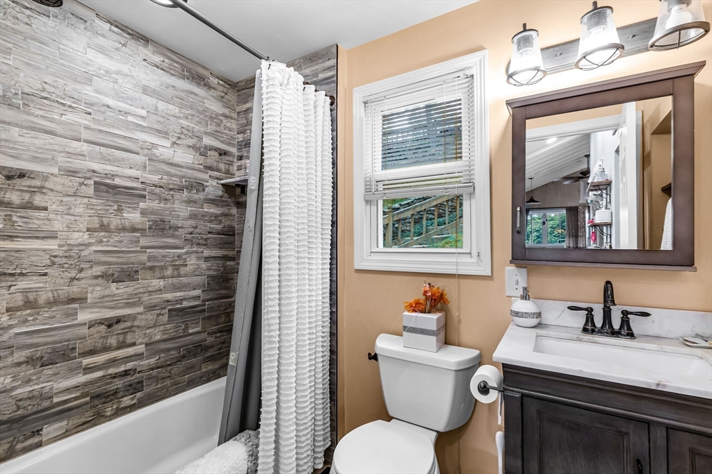 53 Sandy Beach Road Holland, MA 01521 - Photo 29 of 40 a bathroom with a granite countertop sink mirror vanity and toilet