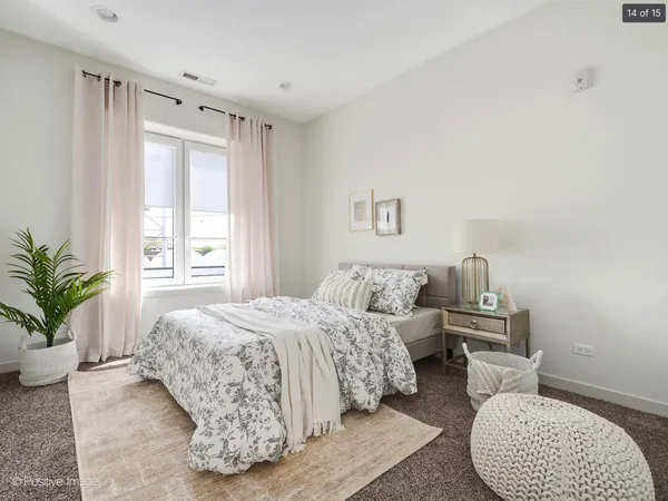 a bedroom with a bed and a potted plant