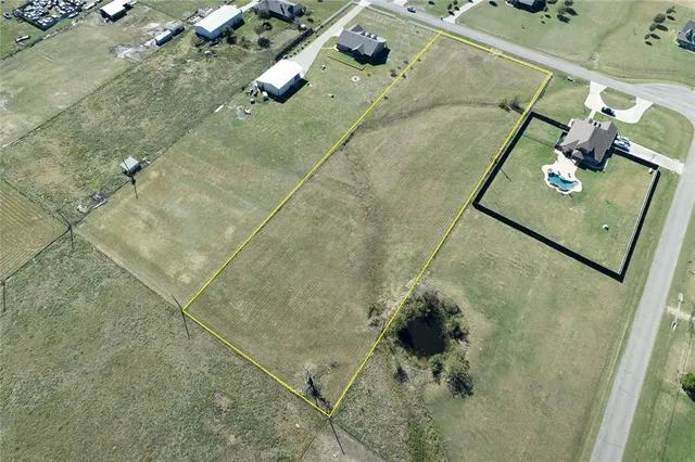 an aerial view of ocean and residential houses with outdoor space