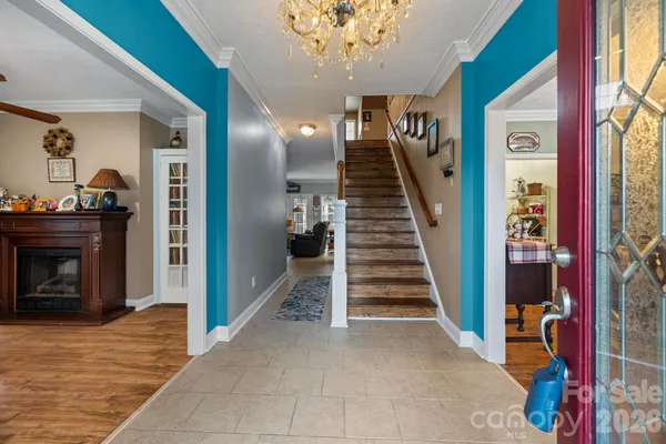 a view of a hallway with a fireplace and chandelier
