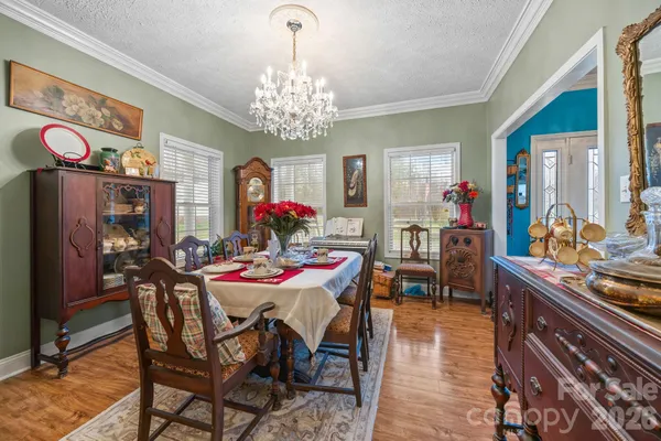 a view of a dining room with furniture a chandelier and wooden floor