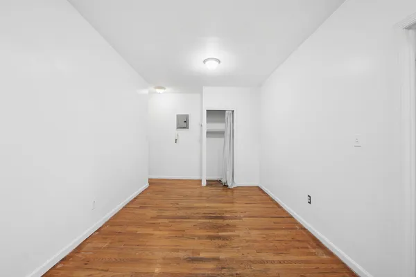 a view of a big room with wooden floor and a ceiling fan