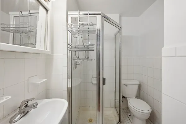 a bathroom with a granite countertop toilet a sink and shower