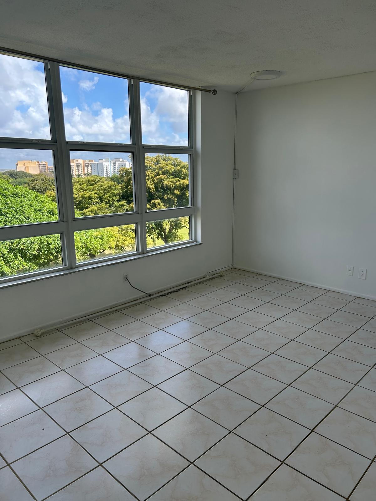 2661 South Course Drive, Unit 703 Pompano Beach, FL 33069 - Photo 9 of 11 a view of an empty room and a large window