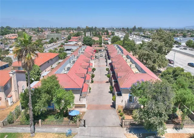 an aerial view of residential houses with outdoor space and trees