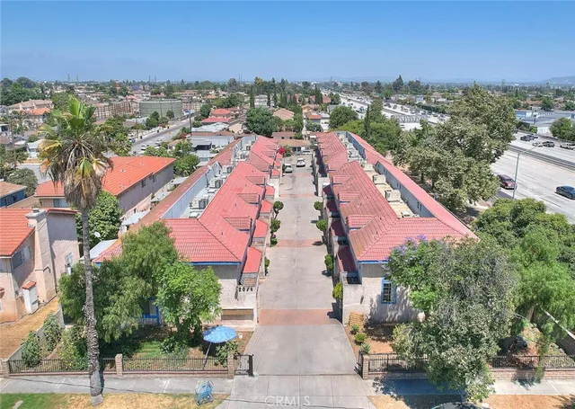 an aerial view of residential houses with outdoor space and trees