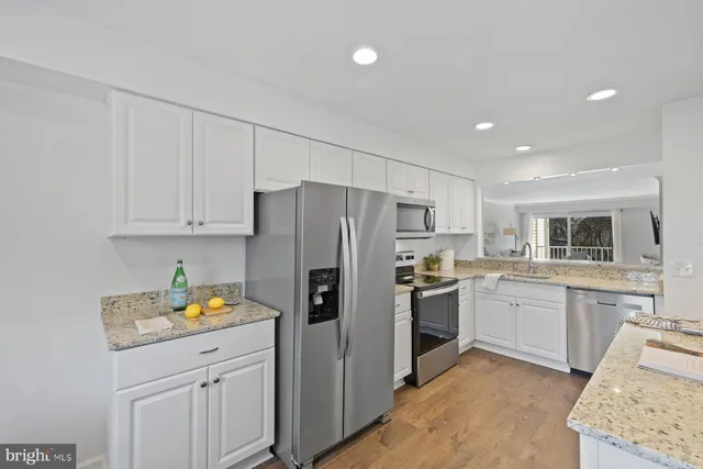 a kitchen with stainless steel appliances granite countertop a refrigerator sink and stove