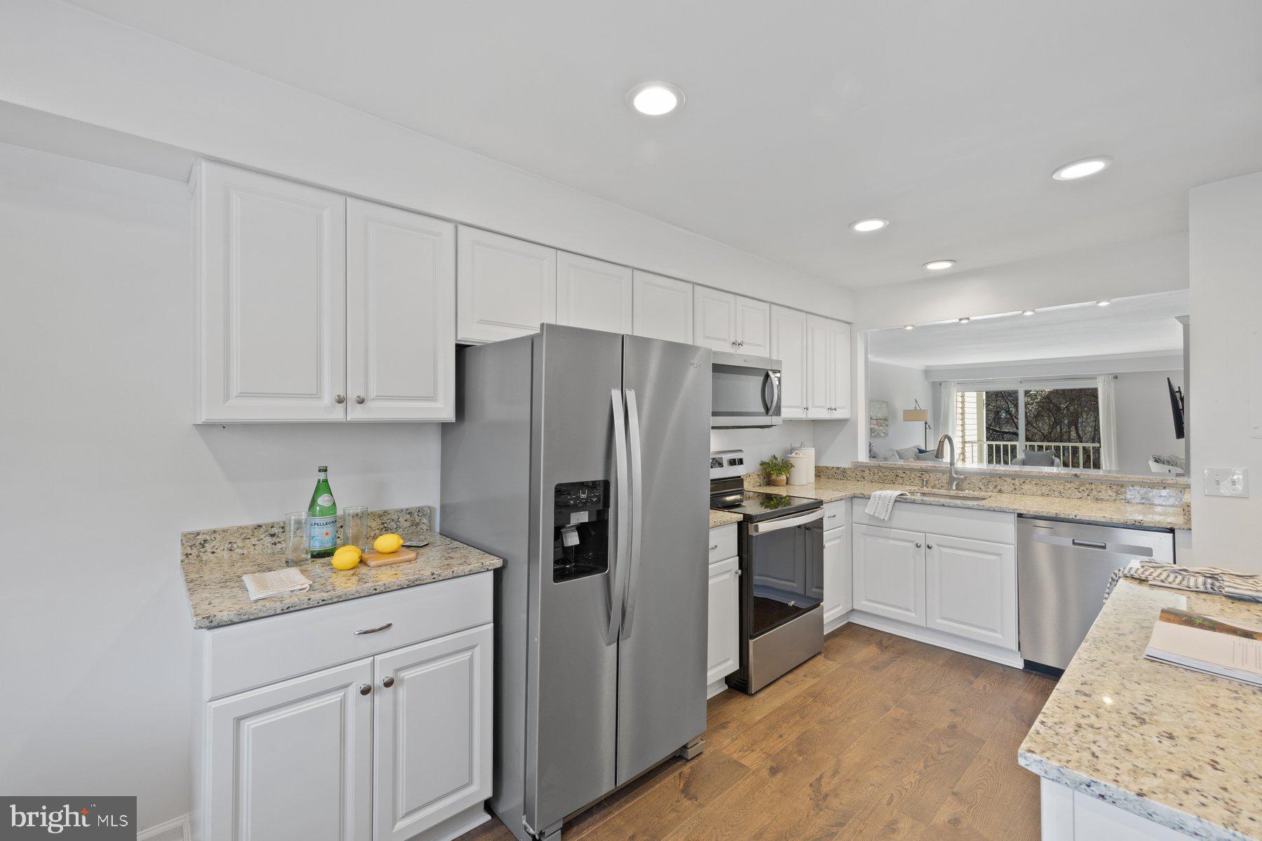 20313 Beaconfield Terrace, Unit 102 Germantown, MD 20874 - Photo 11 of 23 a kitchen with stainless steel appliances granite countertop a refrigerator sink and stove