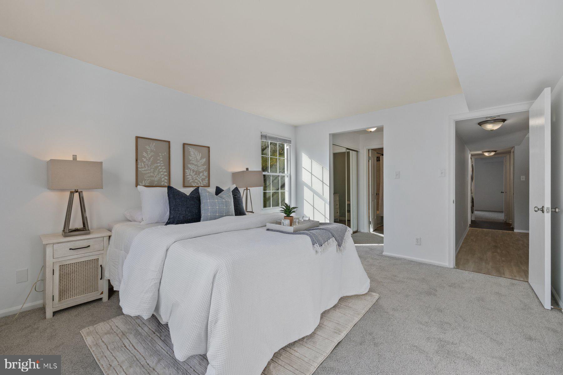 20313 Beaconfield Terrace, Unit 102 Germantown, MD 20874 - Photo 13 of 23 a spacious bedroom with a bed and a lamp