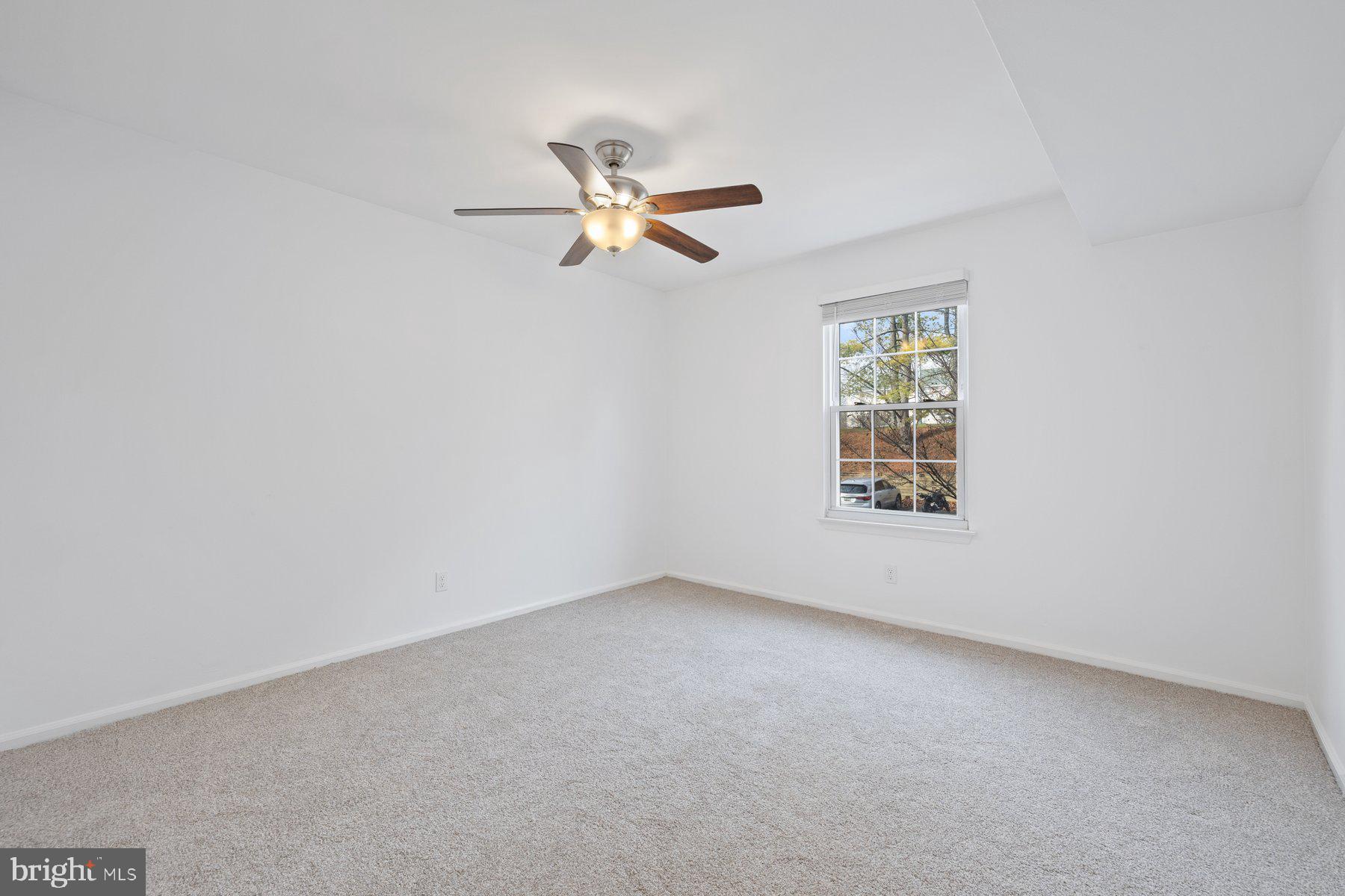 20313 Beaconfield Terrace, Unit 102 Germantown, MD 20874 - Photo 20 of 23 an empty room with a window and ceiling fan