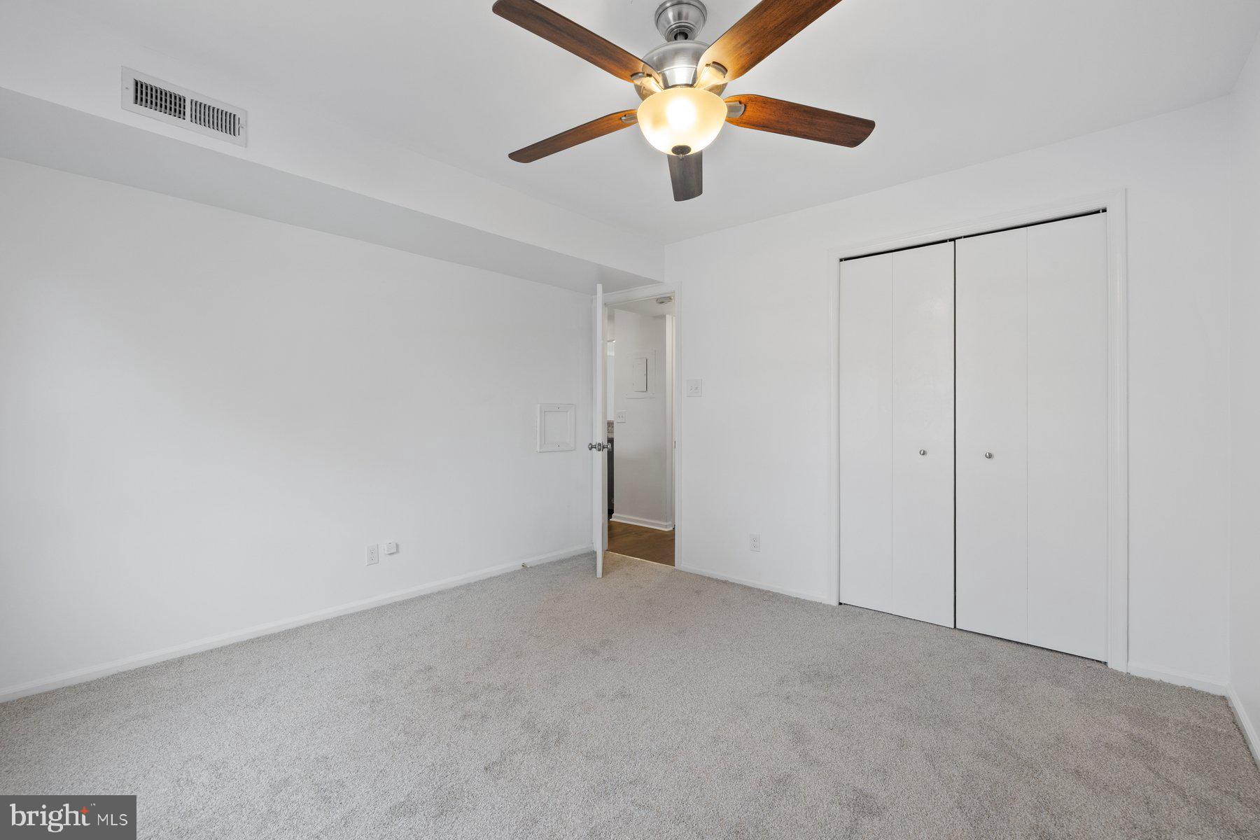 20313 Beaconfield Terrace, Unit 102 Germantown, MD 20874 - Photo 21 of 23 an empty room with closet and a chandelier fan