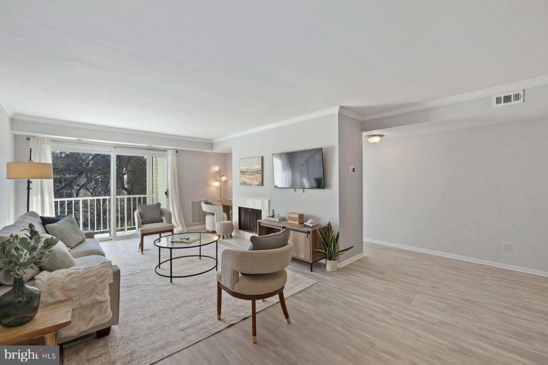 20313 Beaconfield Terrace, Unit 102 Germantown, MD 20874 - Photo 3 of 23 a living room with furniture and a wooden floor