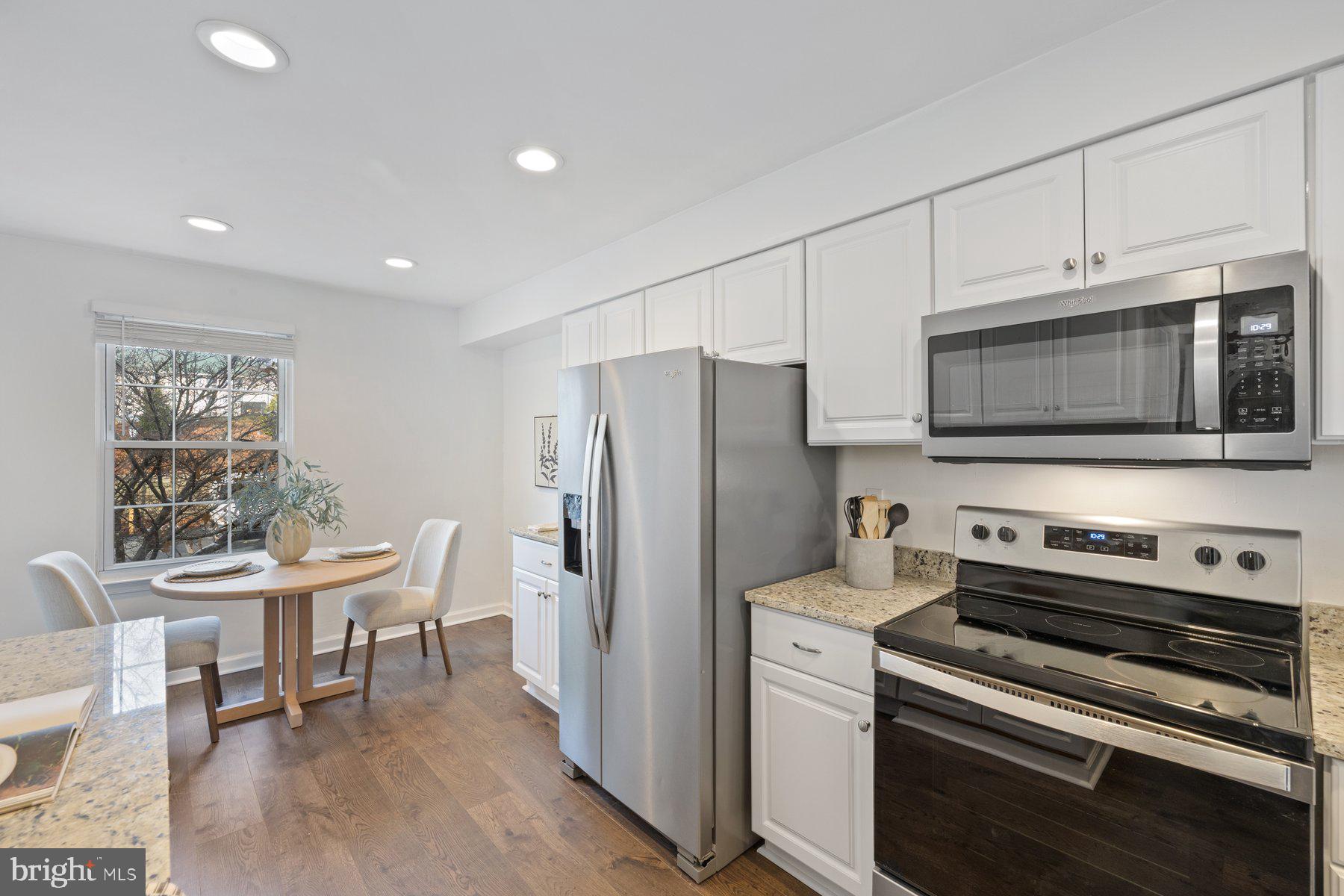 20313 Beaconfield Terrace, Unit 102 Germantown, MD 20874 - Photo 8 of 23 a kitchen with stainless steel appliances a stove a microwave a sink and white cabinets