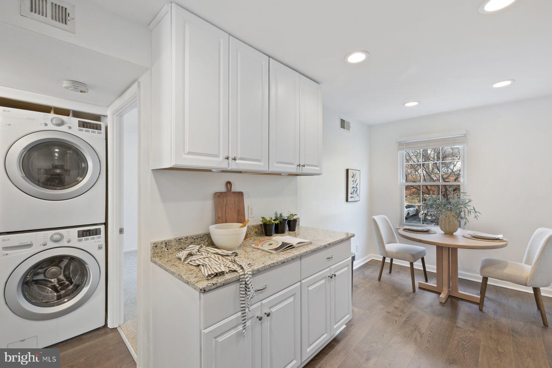 20313 Beaconfield Terrace, Unit 102 Germantown, MD 20874 - Photo 9 of 23 a kitchen with a stove a table and chairs in it