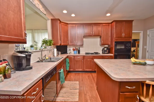 a kitchen with kitchen island granite countertop a sink a counter top space appliances and cabinets