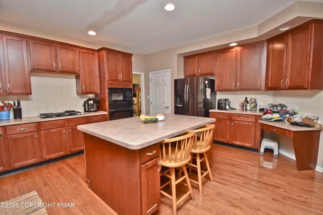 a kitchen with stainless steel appliances granite countertop a kitchen island hardwood floor sink stove and granite counter top