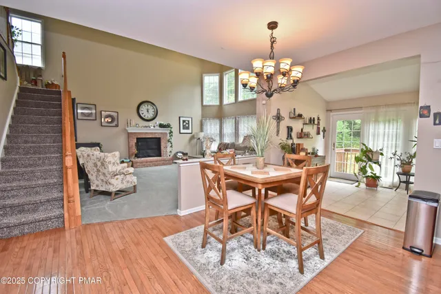 a view of a dining room with furniture a chandelier and wooden floor