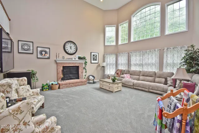 a living room with furniture a fireplace and a large window