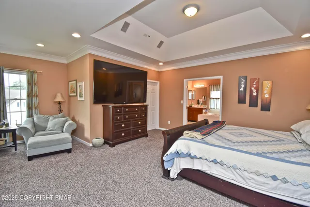 a spacious bedroom with a bed and a flat screen television