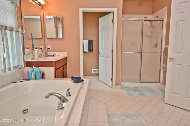 a bathroom with a tub sink and mirror
