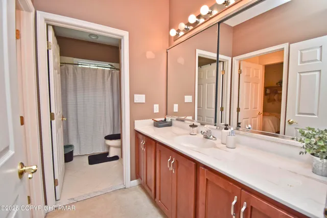 a bathroom with a double vanity sink a mirror and a bathtub