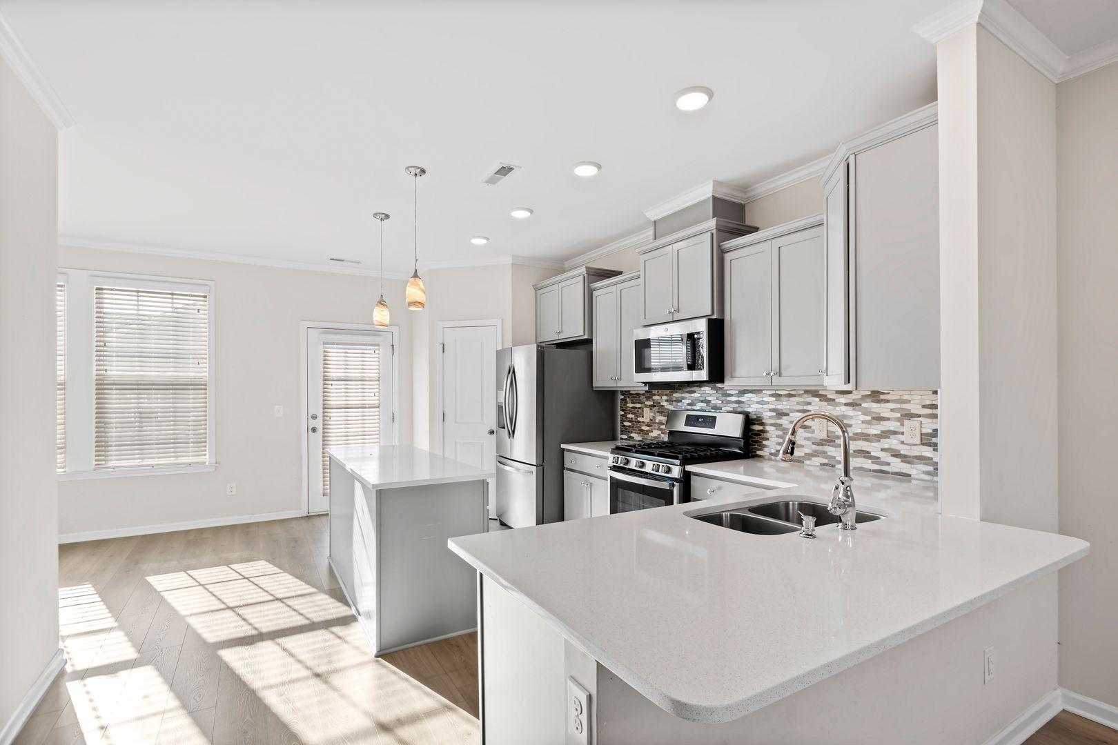6103 Kayton Street Raleigh, NC 27616 - Photo 16 of 45 a kitchen with stainless steel appliances a stove top oven a sink a refrigerator and cabinets