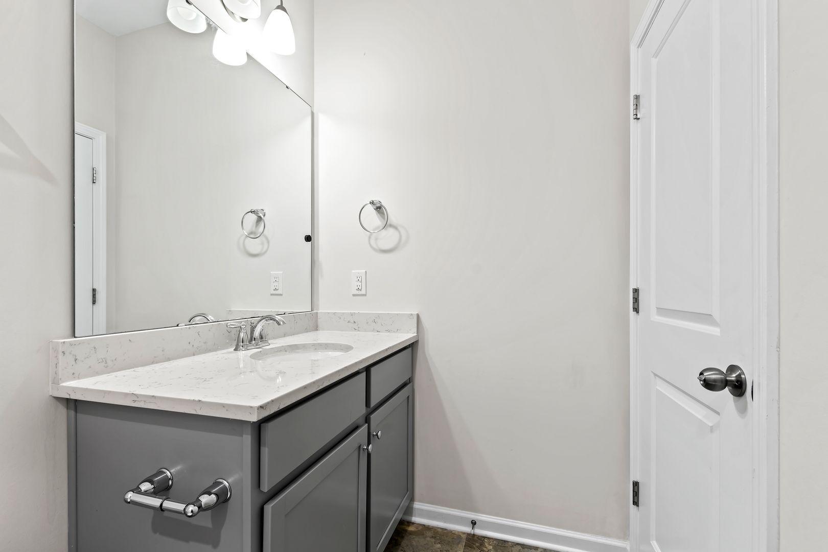 6103 Kayton Street Raleigh, NC 27616 - Photo 35 of 45 a bathroom with a sink a mirror and shower