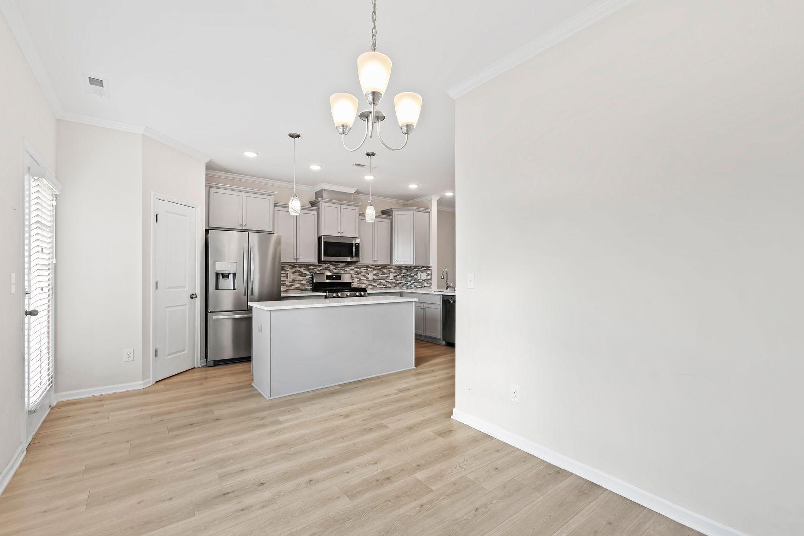 6103 Kayton Street Raleigh, NC 27616 - Photo 9 of 45 a view of kitchen with kitchen island stainless steel appliances sink cabinets and wooden floor