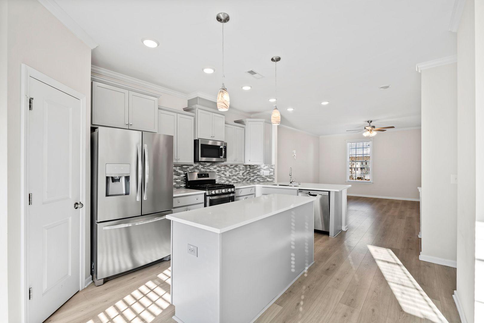 6103 Kayton Street Raleigh, NC 27616 - Photo 10 of 45 a kitchen with white cabinets and stainless steel appliances