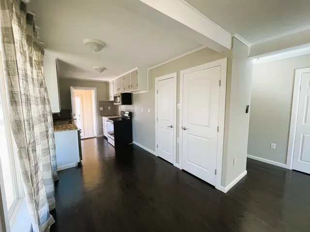 a view of a living room with hardwood floor and a kitchen