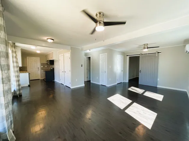a view of a hallway with wooden floor and furniture