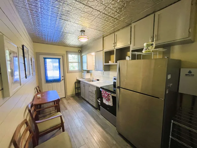 a kitchen with stainless steel appliances granite countertop a refrigerator a stove a sink dishwasher and a refrigerator with wooden floor