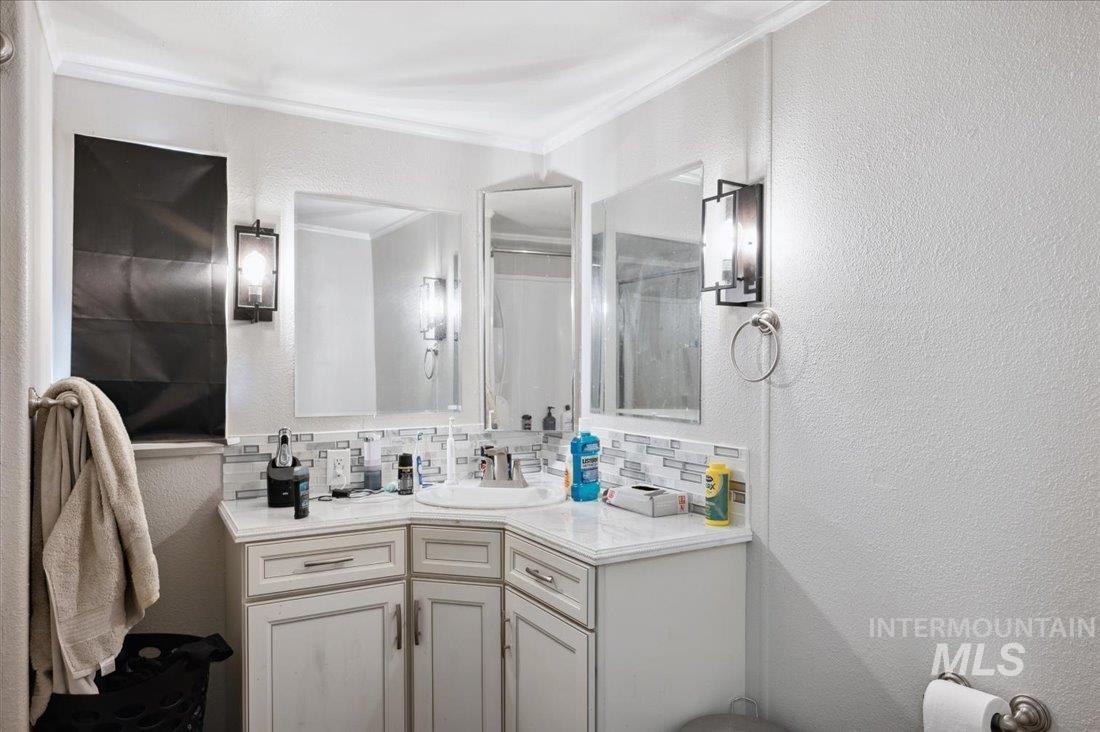 790 North Riviera Drive Boise, ID 83703 - Photo 12 of 15 Bathroom featuring ornamental molding, vanity, tasteful backsplash, and a textured wall
