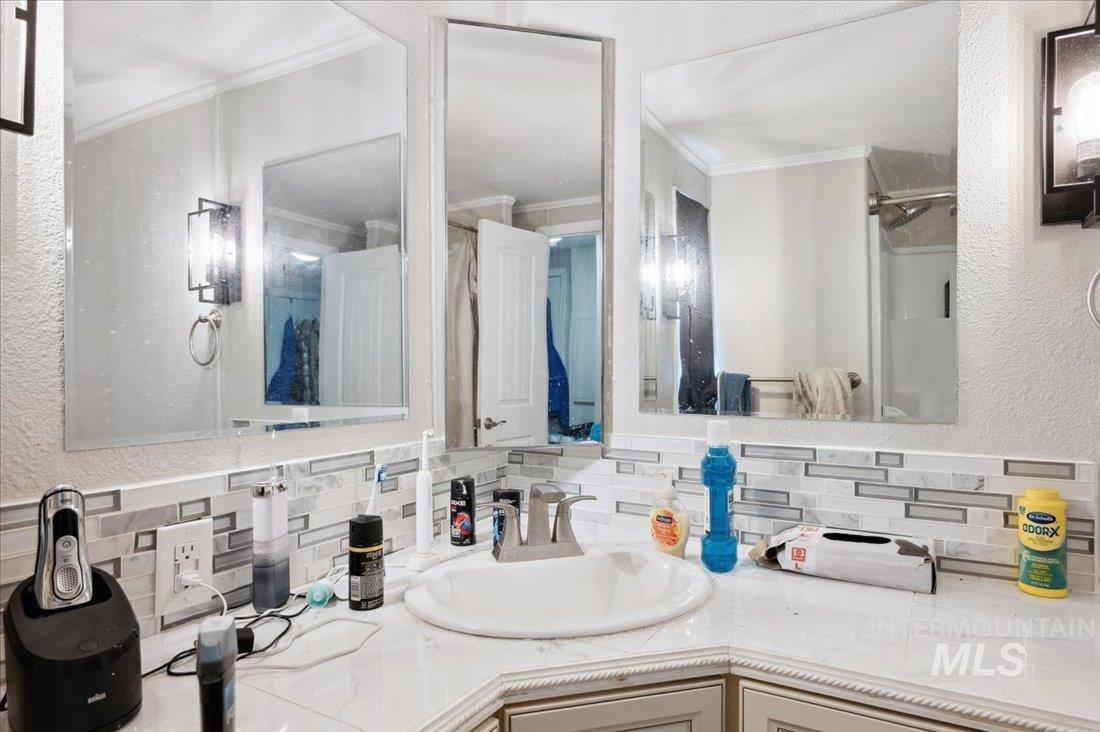 790 North Riviera Drive Boise, ID 83703 - Photo 13 of 15 Bathroom with tasteful backsplash, crown molding, vanity, a shower, and a textured wall