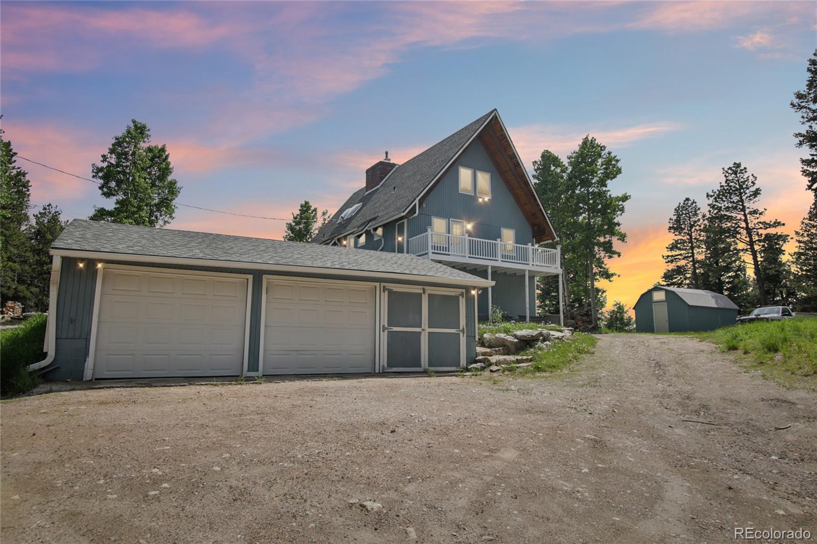 1472 Sinton Road Evergreen, CO 80439 - Photo 3 of 39 front view of a house with a yard and garage