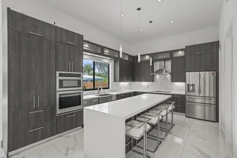 a kitchen with granite countertop a refrigerator and a stove top oven