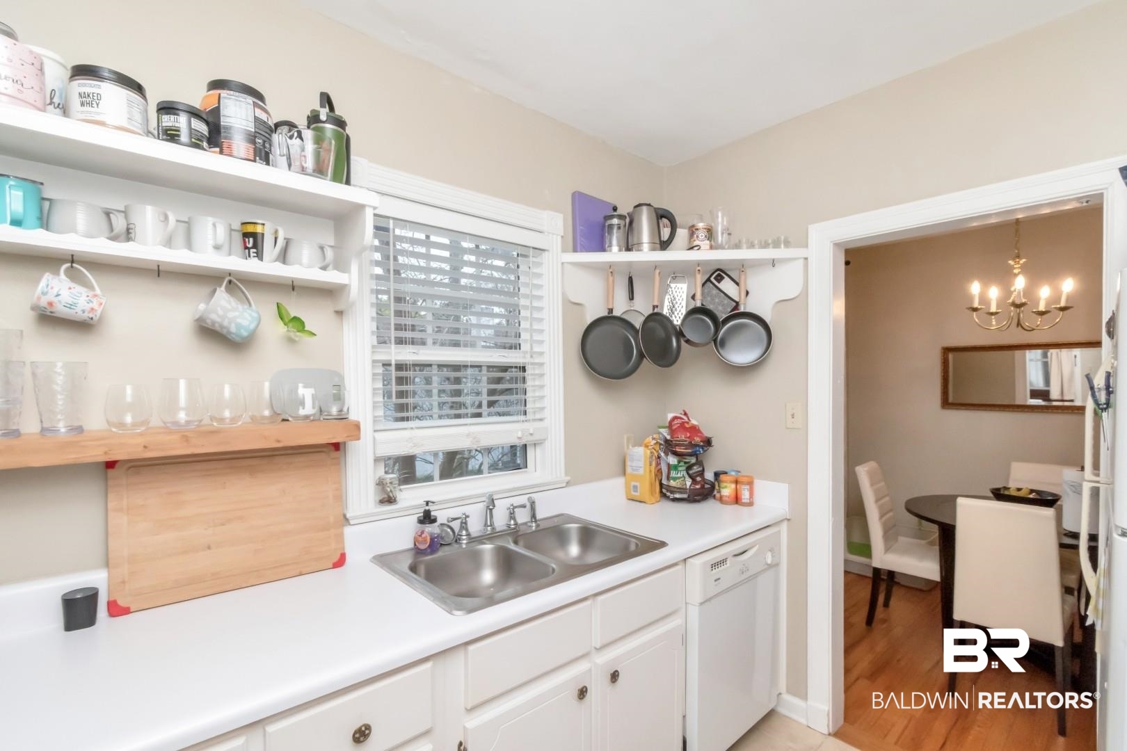 214 Upham Street, Unit 17C Mobile, AL 36607 - Photo 23 of 32 Kitchen featuring open shelves, light countertops, white dishwasher, white cabinets, and a chandelier