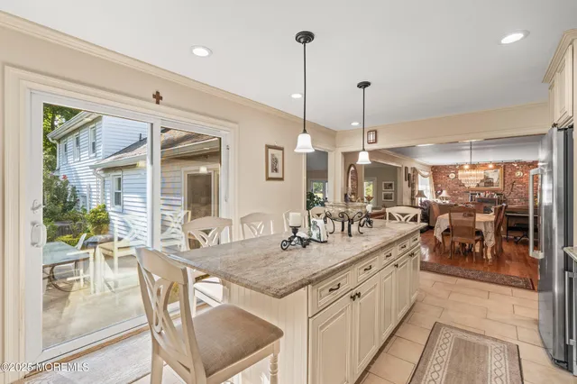 a kitchen with stainless steel appliances kitchen island granite countertop a sink a stove and a wooden floors