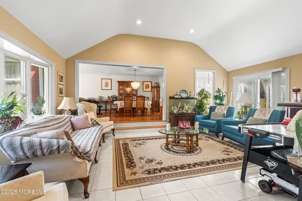 a living room with lots of furniture wooden floor and a chandelier