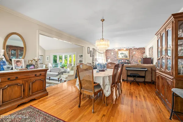 a dining room with furniture a chandelier and wooden floor
