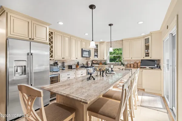 a kitchen with stainless steel appliances kitchen island granite countertop a sink a stove and a wooden floors