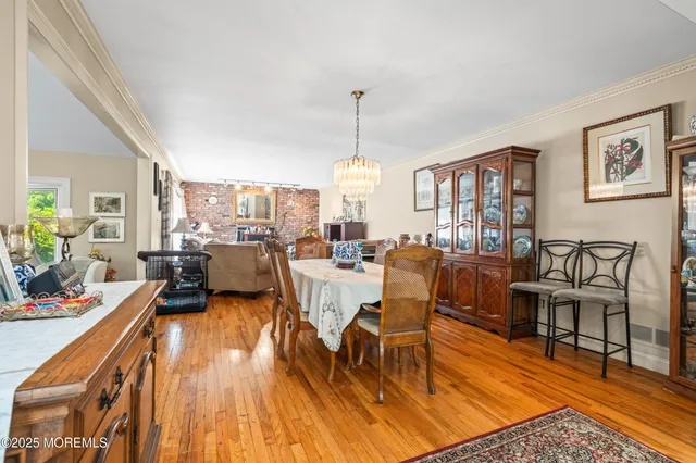 a living room with lots of furniture wooden floor and a chandelier