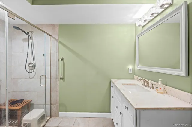 a bathroom with a double vanity sink mirror and shower