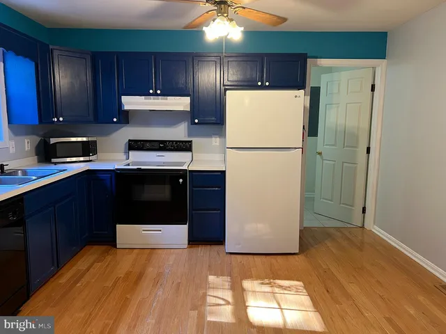 a kitchen with a refrigerator sink and cabinets