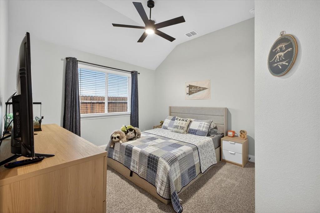 653 Godley Ranch Godley, TX 76044 - Photo 25 of 35 a bedroom with a bed and a chandelier