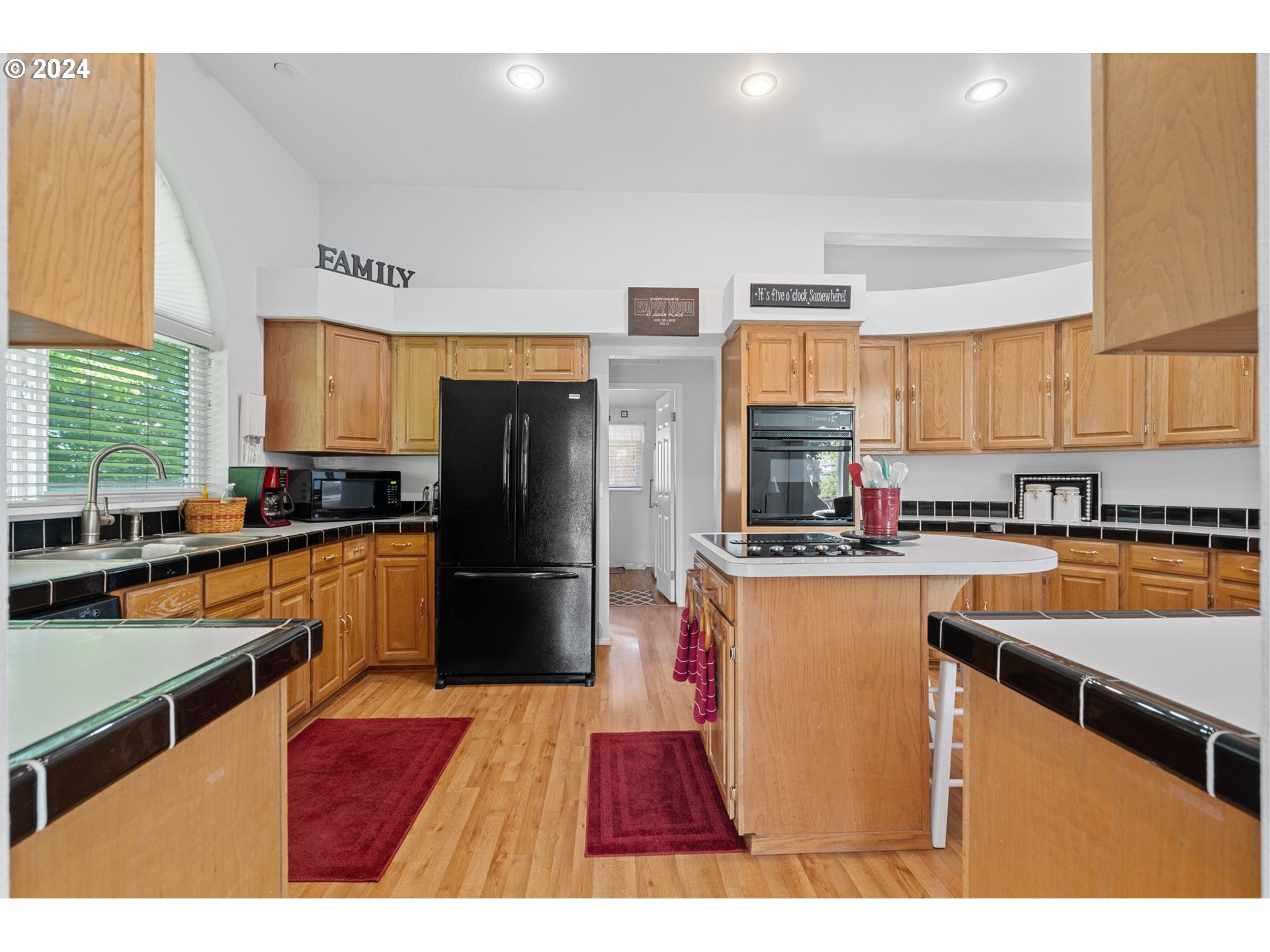 844 6th Street Athena, OR 97813 - Photo 9 of 36 a kitchen with stainless steel appliances granite countertop a refrigerator a sink dishwasher a stove top oven a dining table and chairs with wooden floor