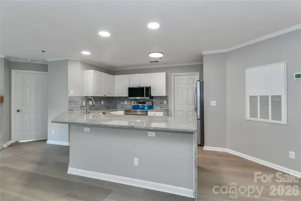 a kitchen with stainless steel appliances granite countertop a sink a stove and a refrigerator