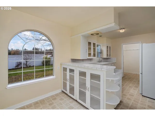 a view of kitchen with granite countertop cabinets and a window