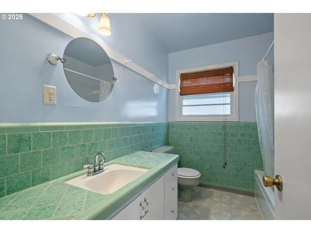 a bathroom with a sink a toilet and mirror