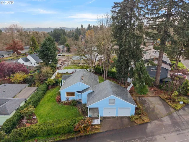 an aerial view of residential houses with outdoor space and trees